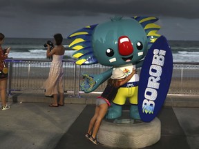 A girl hugs Commonwealth Games mascot, Borobi, at the Surfer's beach in Gold Coast, Australia, Tuesday, April 3, 2018. With the Commonwealth Games opening ceremony marking the beginning of the event on Wednesday night, Bureau of Meteorology forecasters are predicting rain over the Gold Coast throughout the week, up until the weekend.