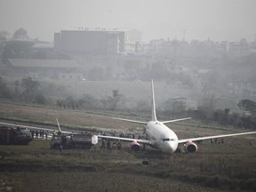 A Malindo Air passenger plane sits after skidding to the grassy area at the end of runway in Tribhuwan International Airport in Kathmandu, Nepal, Friday, April 20, 2018. The Nepal's only international airport remained closed Friday after the passenger plane attempting to take off skidded off the runway. No one was injured.