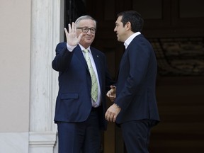 European Commission President Jean-Claude Juncker, left, waves as he is greeted by Greek Prime Minister Alexis Tsipras prior to their meeting in Athens, Thursday, April 26, 2018. Juncker will discuss Greece's fiscal reform plans after its international bailout program ends in a few months' time.