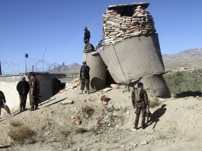 Afghan security personnel stand guard near to Khuja Omari district compound after a deadly Taliban attack in Ghazni, Afghanistan, Thursday, April 12, 2018. The Taliban claimed responsibility for a blistering attack early Thursday morning on a government compound in Afghanistan's central province of Ghazni that killed at least 15 members of the security forces.