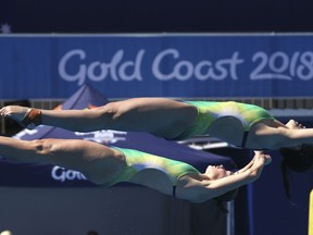 Australia's Esther Qin, top, and Georgia Sheehan, make a dive during the women's synchronised 3m springboard final at the Aquatic Centre during the 2018 Commonwealth Games on the Gold Coast, Australia, Wednesday, April 11, 2018.