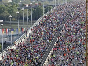 Thousands of athletes cross a bridge over the Danube river shortly after the start of the Vienna city marathon, in Vienna, Austria, on Sunday, April 22, 2018.