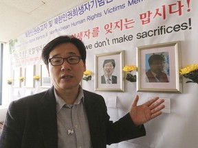 In this April 3, 2018, photo, the Rev. Kim Kyou Ho, head of the Seoul-based Chosen People Network, a Christian group that runs a memorial hall in the South Korean capital for the victims, shows a portrait of the Rev. Han Chung-ryeol, right, a Chinese pastor of Korean descent who headed a front-line church in the Chinese border town of Changbai before he was found dead of multiple stab wounds and a punctured skull in April 2016, at his office in Seoul, South Korea. Missionaries in northeastern China are engaged in a dangerous work: spreading Christianity across the border to North Korea. A South Korean pastor says at least 10 such front-line missionaries and pastors have died mysteriously in recent years.