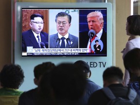 FILE - In this Wednesday, April 18, 2018, file photo, people watch a TV screen showing file footage of U.S. President Donald Trump, right, South Korean President Moon Jae-in and North Korean leader Kim Jong Un, left, during a news program at the Seoul Railway Station in Seoul, South Korea. The upcoming meeting between the leaders of the rival Koreas will be the ultimate test of Moon 's belief that his nation should lead international efforts to deal with North Korea.The signs read: " Summit between South and North Korea, the United States and North Korea."