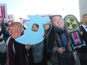 FILE - In this Nov. 2017 file photo, anti-war protesters wearing cutouts of U.S. President Donald Trump and North Korean leader Kim Jong Un, right, march after a rally demanding peace of the Korean peninsula near U.S. Embassy in Seoul, South Korea. When the North and South Korean leaders meet on Friday, April 27, 2018, the prospect of unification, even if only in the abstract, will loom large around them. Both leaders come to the table with distinct visions of what a future would look like. North Korea's founder Kim Il Sung had a plan along the lines of what Hong Kong has with China, a unified nation with two separate systems of government. South Korea's three-step proposal ends in in its own system writ large across the peninsula.