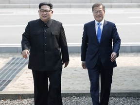 North Korean leader Kim Jong Un, left, walks with South Korean President Moon Jae-in at the border village of Panmunjom in the Demilitarized Zone, South Korea, Friday, April 27, 2018. Kim made history Friday by crossing over the world's most heavily armed border to greet his rival, Moon, for talks on North Korea's nuclear weapons. (Korea Summit Press Pool via AP)