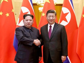 FILE - In this March 28, 2018, file photo, released by China's Xinhua News Agency, North Korean leader Kim Jong Un, left, and Chinese President Xi Jinping poses for a photo in Beijing. Kim made a surprise visit to Beijing recently for a meeting with Xi. That summit reintroduced China as a major player in the diplomatic push to resolve the nuclear standoff and almost certainly strengthened Kim's leverage heading into his talks with South Korean President Moon Jae-in and U.S President Donald Trump.