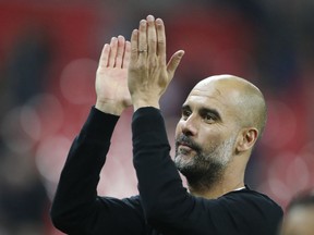 Manchester City manager Pep Guardiola applauds the fans as he walks from the pitch after the end of the English Premier League soccer match between Tottenham Hotspur and Manchester City at Wembley stadium in London, England, Saturday, April 14, 2018.