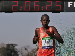 Kenya's Paul Lonyangata celebrates as he crosses the finish line to win the 42nd Paris Marathon men's race, in Paris, Sunday, April 8, 2018.