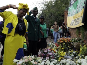 People salute after laying flowers outside the family home of the late Winnie Madikizela-Mandela, in Soweto, South Africa, Wednesday, April 4, 2018. South Africa on Tuesday declared 10 days of national mourning for Winnie Madikizela-Mandela, the anti-apartheid activist and ex-wife of Nelson Mandela who died after a long illness. Madikizela-Mandela's house in Soweto has been visited by mourners since she died on Monday at age 81.