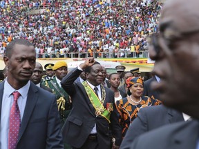 Zimbabwe's President Emmerson Mnangagwa, center, greets the crowd upon his arrival at the National Sports Staduim in Harare, Wednesday, April, 18, 2018, to celebrate the country's 38th anniversary of Independence. Thousands of people gathered for the event which was for the first time without Robert Mugabe as leader since 1980.