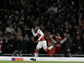 Arsenal's Alexandre Lacazette celebrates after scoring the opening goal of his team during the Europa League semifinal first leg soccer match between Arsenal FC and Atletico Madrid at Emirates Stadium in London, Thursday, April 26, 2018.