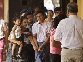 Reuters journalist Kyaw Soe Oo, center, is welcomed by his wife Chit Su Win, second left, and his daughter as he arrives at the court for his trial, Wednesday, April. 4, 2018, Yangon, Myanmar.