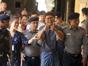 Reuters journalist Wa Lone, centre, walks along with his wife Pan Ei Mon, second left, as he is escorted by police upon arrival at his trial Wednesday, April.11, 2018 in Yangon, Myanmar.