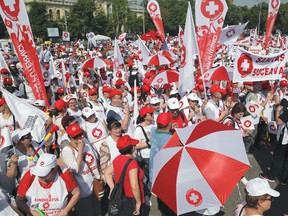 Romanian health system employees protest outside the Romanian government headquarters, threatening with a general strike, in Bucharest, Romania, Thursday, April 26, 2018. Thousands, from across the country, joined a rally protesting against the income law and newly introduced changes in the regulations governing bonuses, which they say, lead to significant losses for the employees.