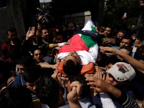 Mourners and journalists carry the body of Palestinian journalist Yasser Murtaja, during his funeral in Gaza City on April 7, 2018. Among those killed at Friday's protest was Yasser Murtaja, a photographer with the Gaza-based Ain Media agency, who died from his wounds after being shot, the local health ministry said.