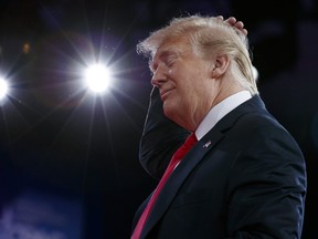 Donald Trump gestures as he makes a joke about his hair during remarks to the Conservative Political Action Conference, Friday, Feb. 23, 2018, in Oxon Hill, Md.