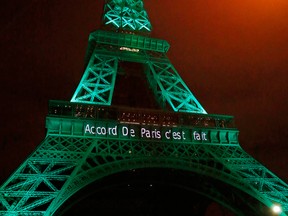 In this file photo dated Friday Nov.4, 2016, the Eiffel Tower lit up in green to mark the success of the Paris Agreement to slash man-made emissions of carbon dioxide and other global warming gases to counter climate change, in Paris. Inscription reads, "it's done.”