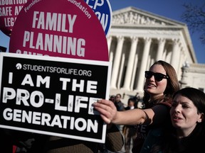 A pro-life activist tries to block the signs of pro-choice activists in front of the the U.S. Supreme Court during the 2018 March for Life January 19, 2018 in Washington, DC.