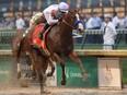 Justify, ridden by jockey Mike Smith, crosses the finish line to win the 144th running of the Kentucky Derby on Saturday at Churchill Downs in Louisville, Ky.