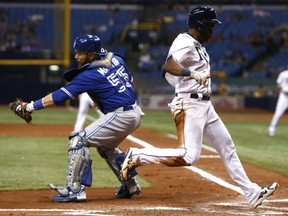 Denard Span of the Tampa Bay Rays beats catcher Russell Martin of the Toronto Blue Jays to home plate as he scores off of a sacrifice fly by Matt Duffy during the fourth inning of their game Saturday night at Tropicana Field in St. Petersburg, Fla.