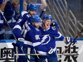 Ondrej Palat, right, celebrates with his teammates Victor Hedman and Steven Stamkos after scoring during the first period of Game 5 at Amalie Arena on May 19, 2018.