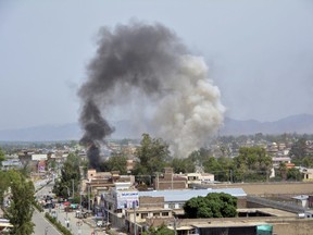 Smoke rises from the site of a deadly militant attack on a government building that killed at least nine people, in Jalalabad, east of Kabul, Afghanistan, Sunday, May 13, 2018.
