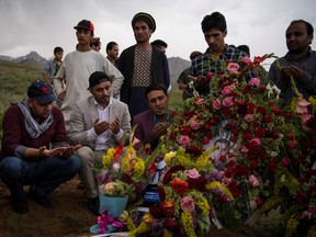 Friends and relatives of Agence France Presse Afghanistan Chief Photographer Shah Marai Faizi gather at his burial in Gul Dara, Kabul on April 30, 2018, after his death in the second of two bombings that occurred in the Afghan capital.