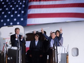 U.S. President Donald Trump applauds as US detainee Kim Dong-chul gestures upon his return with Kim Hak-song and Tony Kim after they were released by North Korea, at Joint Base Andrews in Maryland on May 10, 2018.