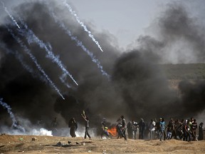 Tear gas is fired at protestors during clashes with Israeli forces near the border between the Gaza strip and Israel, east of Gaza City on May 14, 2018, following the the controversial move to Jerusalem of the United States embassy.