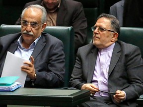 In this file photo taken on August 15, 2017, the Governor of the Central Bank of Iran, Valiollah Seif (R), sits with Iran's nominated Minister of Economic Affairs and Finance Massoud Karbasiyanat a parliament session in Tehran.