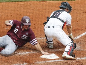 Texas A&M infielder Chris Andritsos (40) beats the tag of Georgia catcher Mason Meadows (30) as he slides into home plate during the fourth inning of a Southeastern Conference Tournament NCAA college baseball game, Wednesday, May 23, 2018, in Hoover, Ala.