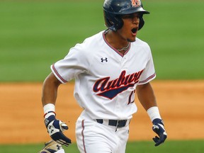 Auburn infielder Will Holland (17) celebrates as he runs home after hitting a home run during the first inning of a Southeastern Conference NCAA college baseball game against Kentucky, Tuesday, May 22, 2018, in Hoover, Ala.