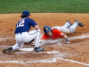 Auburn's Luke Jarvis (9) beats the tag from Mississippi pitcher Greer Holston (12) as he slides into home plate on a wild pitch during the seventh inning of a Southeastern Conference Tournament NCAA college baseball game, Wednesday, May 23, 2018, in Hoover, Ala.