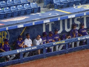 LSU players sit in the dugout during a rain delay in the third inning of a Southeastern Conference tournament NCAA college baseball game against Arkansas, Saturday, May 26, 2018, in Hoover, Ala.