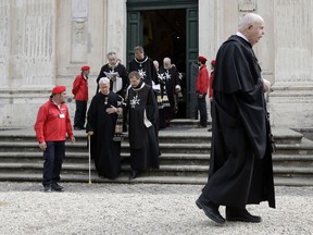 Knights of Malta Fra' Ludwig Hoffmann von Rumerstein, left, with walking stick is helped by Albrecht von Boeselager, former Grand Chancellor, as they follow Lieutenant Giacomo Dalla Torre del Tempio di Sanguinetto, right, during a procession before the election of the new Grand Master, at the order's Villa Magistrale on Rome's Aventine Hill ahead of the secret balloting, Wednesday, May 2, 2018.