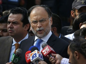 FILE - In this Oct. 2, 2017 file photo, Pakistani Interior Minister Ahsan Iqbal talks to journalists outside the accountability court, in Islamabad, Pakistan. Pakistani officials said Sunday, May 6, 2018, that a gunman opened fire on Iqbal after a public meeting, wounding him in shoulder.