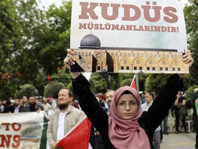 Members of pro-Islamic NGO IHH and other groups holding Turkish and Palestinian flags stage a rally following Friday prayers in Istanbul, Friday, May 11, 2018 to protest the US decision to relocate its Israeli embassy to Jerusalem. The embassy is moving from Tel Aviv in line with President Donald Trump's recognition of Jerusalem as Israel's capital. The placard in Turkish reads: " Jerusalem belongs to the Muslims."