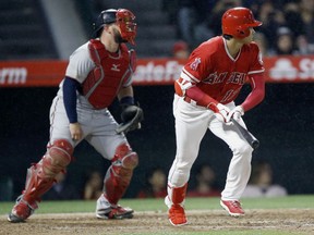 Los Angeles Angels designated hitter Shohei Ohtani, right, of Japan, hits a single to load the bases with Minnesota Twins catcher Bobby Wilson watching during the fifth inning of a baseball game in Anaheim, Calif., Friday, May 11, 2018.