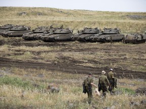 Israeli soldiers walk past tanks in the Israeli-controlled Golan Heights, near the border with Syria, Thursday, May 10, 2018. Israel says it struck dozens of Iranian targets in Syria overnight in response to a rocket barrage on Israeli positions in the Golan Heights. It was the biggest Israeli strike in Syria since the 1973 war.