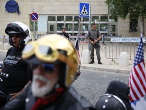 Security personnel stand guard as riders from the Samson Riders, an Israeli motorcycle club arrive to the new U.S. Embassy on a group ride from the old embassy in Tel Aviv, ahead of the official opening, in Jerusalem, Sunday, May 13, 2018. On Monday, the United States moves its embassy in Israel from Tel Aviv to Jerusalem, the holy city at the explosive core of the Israeli-Palestinian conflict and claimed by both sides as a capital.