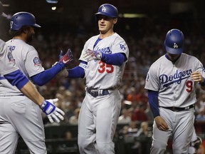 Los Angeles Dodgers' Cody Bellinger (35) celebrates his two-run home run with Matt Kemp, left, and Yasmani Grandal (9) during the third inning of a baseball game against the Arizona Diamondbacks on Tuesday, May 1, 2018, in Phoenix.