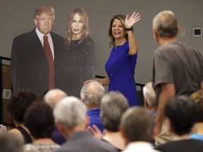 In this Tuesday, May 8, 2018 photo, U.S. Senatorial candidate Kelli Ward waves to volunteers and voters as she walks past a cardboard cut-out of President Donald Trump and the first lady Melania Trump during the Sun Lakes Republican Club meeting in Sun Lakes, Ariz. After teacher walkouts, a competitive senate race and a special election that Republicans almost lost in one of the most conservative congressional districts in the nation, Democrats are pinning their hopes, again, on Arizona. For a decade, Democrats have said they were close to turning Arizona blue.