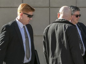 File - In this March 21, 2018 file photo, Border Patrol agent Lonnie Swartz, left, makes his way to the U.S. District Court building in downtown Tucson, Ariz., where opening arguments are scheduled to begin in the his murder trial in Tucson. Swartz, who was acquitted of second-degree murder in a case that ended in mistrial will be retried on lesser charges, the attorney for the family of the rock-throwing teen killed in a 2012 cross-border shooting said Friday, May 11, 2018. Attorney Luis Parra, of Nogales, Ariz., said in was in the federal courtroom in Tucson when U.S. prosecutors announced they would retry agent Lonnie Swartz for manslaughter. He said the new trial was set for Oct. 23 and is expected to last two months.