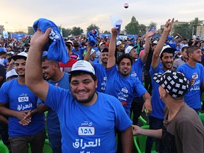 In this Tuesday, May 1, 2018 photo, supporters cheer Iraq Prime Minister Haider al-Abadi as he speaks during a parliamentary campaign rally in Baghdad, Iraq. Voters head to the polls next weekend for the first time since the government declared victory against the Islamic State group, in elections that could tilt the balance of power between the United States and Iran. The atrocities committed by IS against fellow Sunnis, and the national campaign against the extremist group, seem to have eased the sectarian tensions that marked past votes.