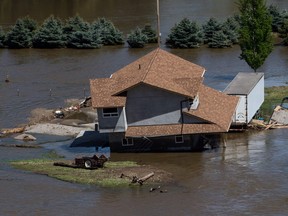 A home damaged by flood waters is seen in an aerial view, near the Kettle River in Grand Forks, B.C., on Saturday May 12, 2018.