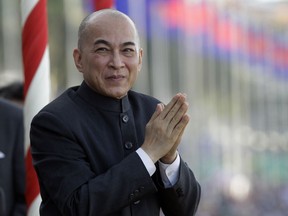 FILE - In this Thursday, Nov. 2, 2017, file photo, Cambodia's King Norodom Sihamoni greets government officers as he watches the boat races during a water festival in Phnom Penh, Cambodia. Cambodia's Cabinet has endorsed a law making insulting the king a criminal offense punishable by monetary fines and up to five years in prison.