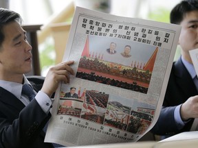 FILE - In this May 8, 2016, file photo, North Koreans read their leader Kim Jong Un's speech published in the local newspaper in Pyongyang, North Korea. Donald Trump and Kim Jong Un have one big thing in common as they prepare for what would be the first ever U.S.-North Korea summit: They both claim to deserve total credit. In a country where there is no Twitter but lots of fake news, North Koreans are getting a very different take on what got the two leaders to agree to meet next month in Singapore.