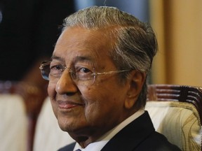 FILE - In this Wednesday, May 16, 2018, file photo, Malaysian Prime Minister Mahathir Mohamad smiles during press conference in Putrajaya, Malaysia. Mahathir said Wednesday the government will set up a trust fund to let the public contribute to easing the country's huge national debt.
