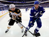 Brayden Point of the Tampa Bay Lightning fights Brad Marchand of the Boston Bruins for the puck.